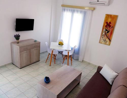 - un salon avec un canapé et une table dans l'établissement Flora Apartments, à Drios