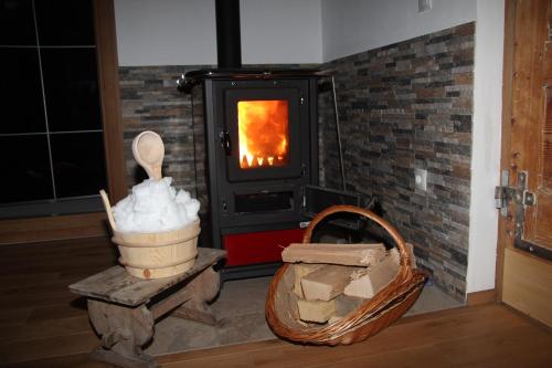 a wood stove with a fire in a room at Exklusives Naturjuwel - Kühbartl Simmerl in Oberhaag