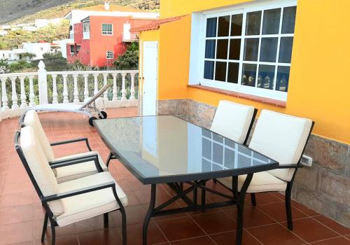einen Glastisch und zwei Stühle auf dem Balkon in der Unterkunft Vista Guapa in Frontera