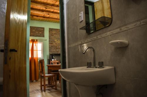 a bathroom with a sink and a mirror on the wall at Cabañas de la bodega Romano-Pin in Albardón