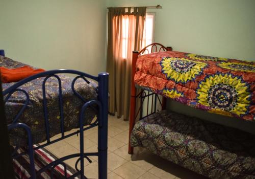 a bedroom with two bunk beds and a window at Cabañas de la bodega Romano-Pin in Albardón