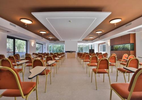 an empty room with chairs and tables and a podium at Hotel Hermitage in Galatina