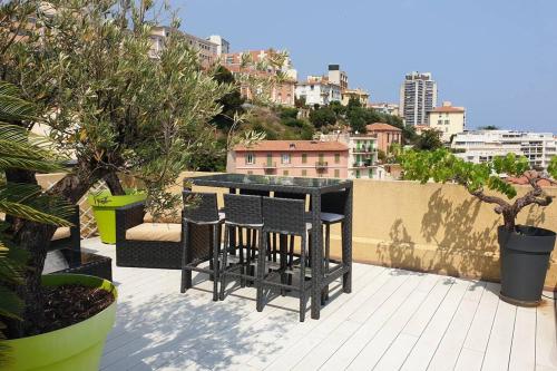 a balcony with a table and some plants and buildings at Penthouses+Terrasse 60 m2+Box 2 Vehicules in Beausoleil