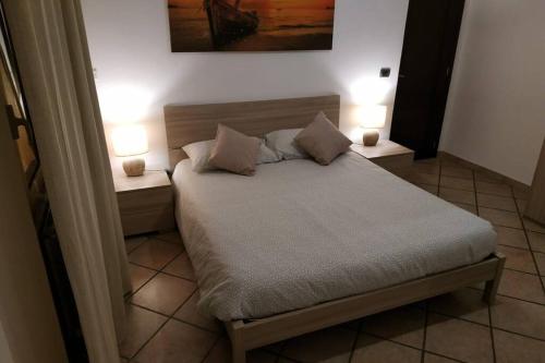 a bedroom with a bed with two lamps on it at Camera confortevole tra Roma e Ostia in Acilia