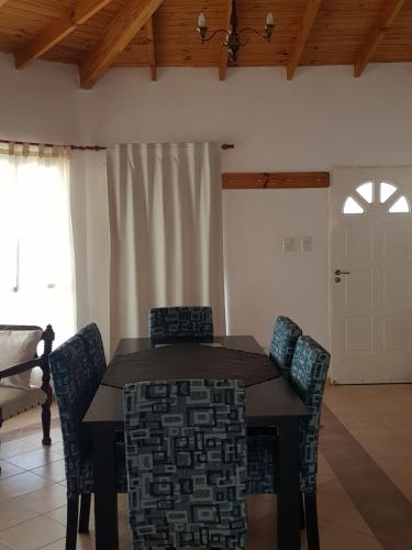 a dining room with a wooden table and chairs at Las Condalias in Puerto Madryn