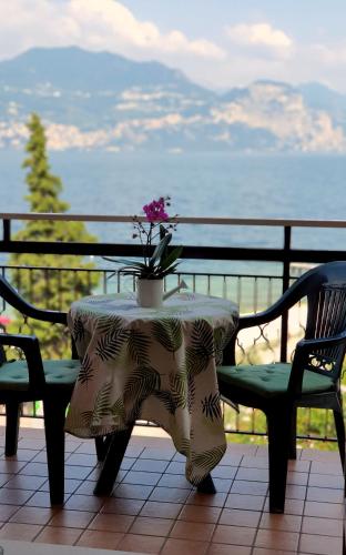 a table with a flower on it with two chairs at Hotel Merano in Brenzone sul Garda
