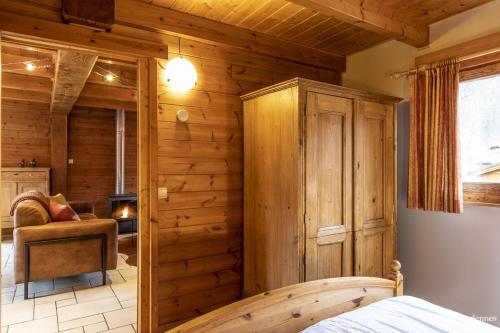 een slaapkamer met houten wanden en een bed in een kamer bij Chalet Val de l'Amblève in Sougné-Remouchamps
