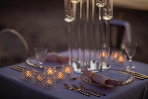a table with a blue table cloth with lights on it at Marbella Beach Hotel in Golem