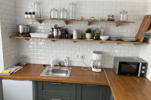 un comptoir de cuisine avec un évier et un micro-ondes dans l'établissement Villa SAGRADA - LE BOHEME ****, à Toulouse
