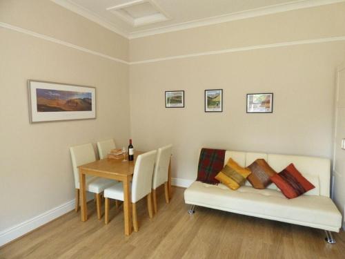 a dining room with a table and a couch and a table and chairs at Great location, quiet yet 5 mins to Bowness centre with walks from the door and parking in Bowness-on-Windermere