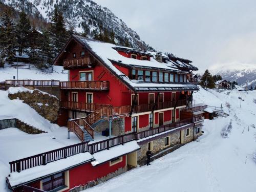 a large red building with snow on the roof at Hotel Piccolo Chalet in Claviere