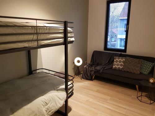 - une chambre avec des lits superposés et un canapé dans l'établissement Vakantiewoning Ijzerfront 14-18, à Dixmude