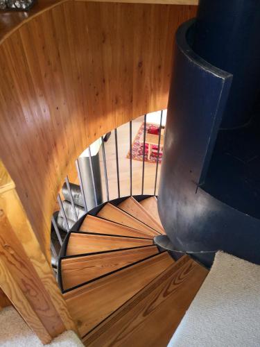 a spiral staircase in a house with a wooden ceiling at le chalet pointu de capucine in Bourg-Saint-Maurice