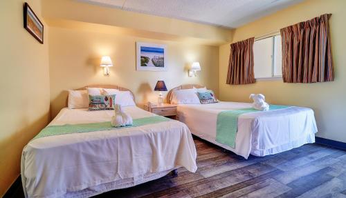 מיטה או מיטות בחדר ב-Acacia Beachfront Resort