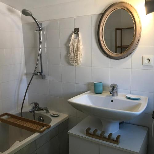 une salle de bain avec un lavabo et un miroir dans l'établissement Maylou Baan, à Marseillan