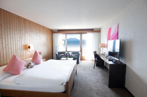 ベアテンベルクにあるHotel Gloriaのベッド、デスク、テレビが備わるホテルルームです。