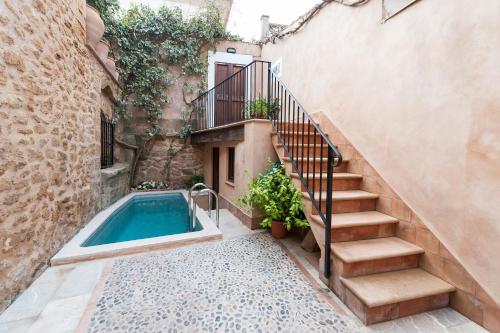 a house with a swimming pool next to a stairs at CA NA BLANCA in Alcudia