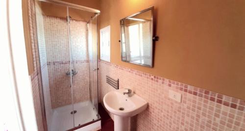 uma casa de banho com um lavatório e um chuveiro com um espelho. em Las Toscas em Jerez de la Frontera