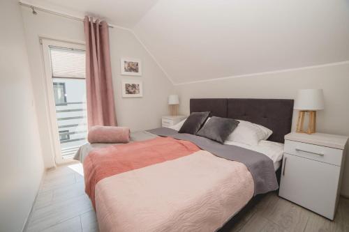 a bedroom with a large bed and a window at Zagroda Wrzosowa in Dębki