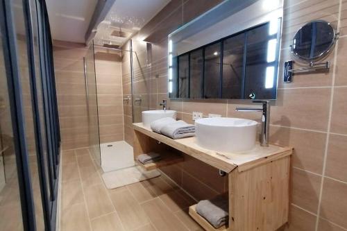 a bathroom with two sinks and a shower at Maison tout équipée! Avec SALLE DE CINÉMA!!! in Le Pener