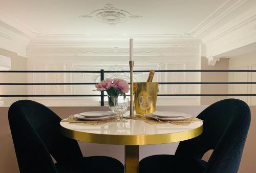un tavolo con due sedie e un tavolo con fiori di INTOMILAN Galleria Duomo I Boutique & Design Aparthotel a Milano