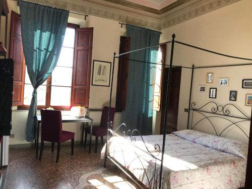 a bedroom with a bed and a desk and a table at Relais Lorebian in Pisa