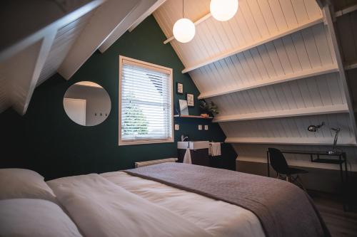 a bedroom with a bed and a desk and a window at Je B&B Giethoorn, incl fietsen! in Giethoorn