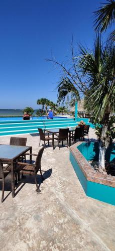 a group of tables and benches next to a pool at The Crimson Orchid Inn at Orchid Bay in Corozal
