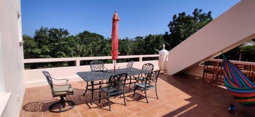 a patio with a table and chairs on a balcony at The Crimson Orchid Inn at Orchid Bay in Corozal