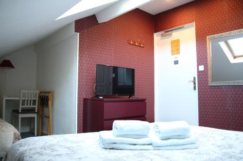 a bedroom with a bed and a tv on a wall at Hotel Saint Yves in Nantes