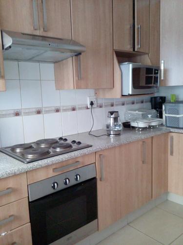 una cucina con fornelli e microonde di Tlelakufuma Guest House a Johannesburg