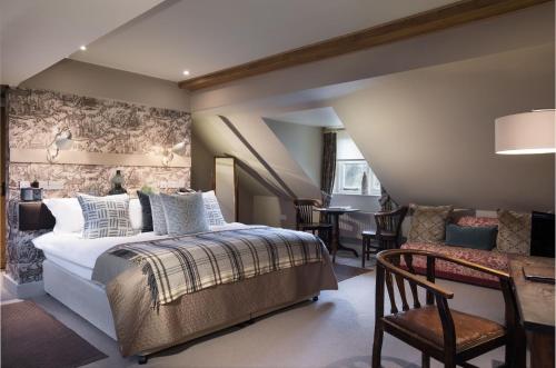 1 dormitorio con 1 cama, mesa y sillas en The Howard Arms, en Ilmington