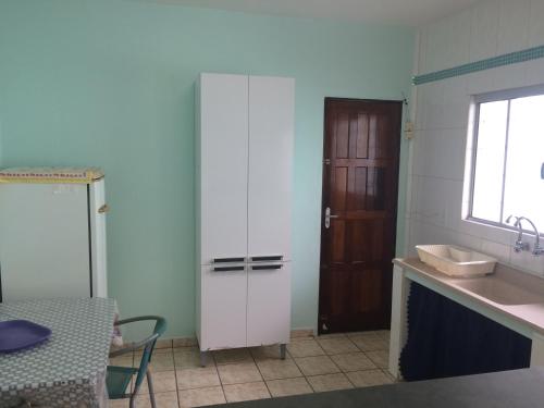 圣塞巴斯蒂安Casa com Amplo quintal no Canto do Mar的厨房设有水槽、柜台和门