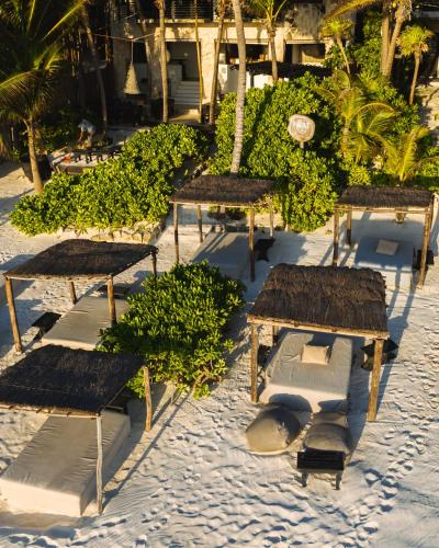 a group of benches sitting on the beach at NEST Tulum in Tulum