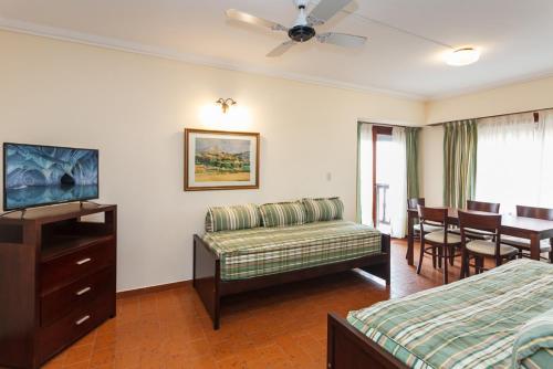 um quarto de hotel com um sofá e uma sala de jantar em Terrazas Playa em Villa Gesell
