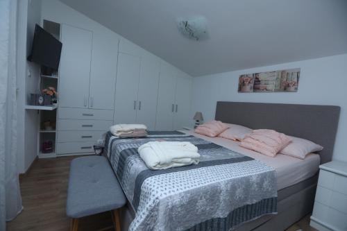 a bedroom with a bed with pink pillows on it at Villa Susann in Šibenik