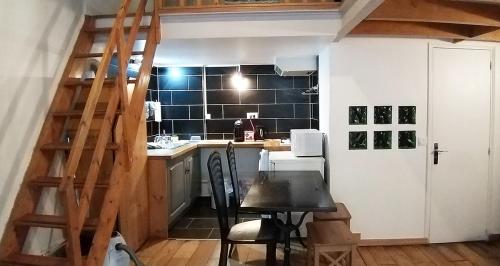 une petite cuisine avec une table et un escalier dans l'établissement ESPACE PARISIEN-CÔTÉ D'EUROSTAR, à Paris