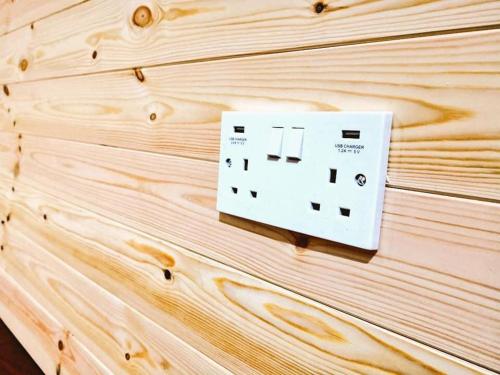 a light switch on a wooden wall at North Point Pods NC500 in Thurso