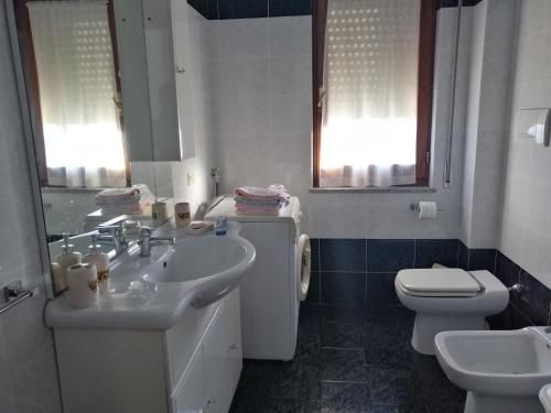 GagliatoにあるAppartamento vacanze Gagliatoの白いバスルーム(洗面台、トイレ付)