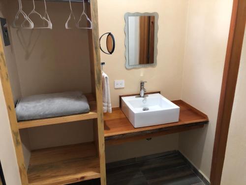 a bathroom with a sink and a mirror at Hotel "Casa Las Lolas" in Xpujil