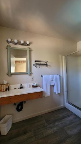 a bathroom with a toilet, sink and mirror at Sequoia Lodge in Kernville