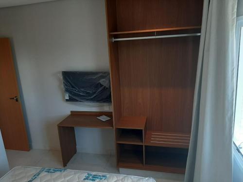 a bedroom with a wooden cabinet and a desk at SALINAS EXCLUSIVE RESORT in Salinópolis