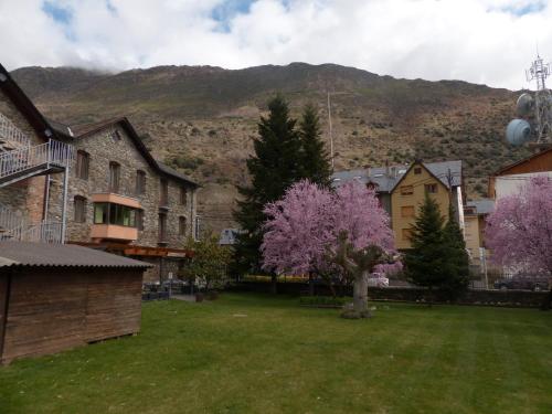 a group of houses and trees with mountains in the background at Hostal Vall D'Aneu by Arcas & Sambola in Esterri d'Àneu