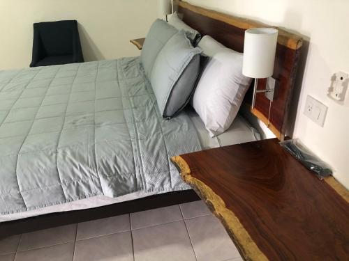 a bedroom with a bed with a wooden headboard and a table at Hotel "Casa Las Lolas" in Xpujil