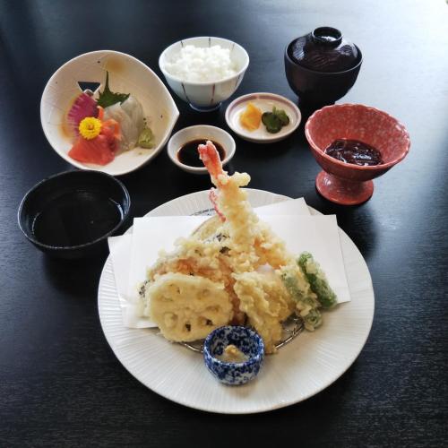 a plate of food on a table with bowls of food at Sky Hotel Namerikawa in Namerikawa