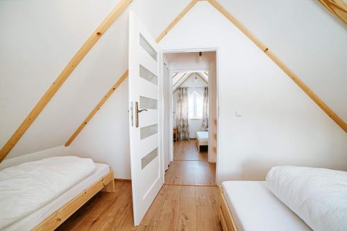 Dormitorio pequeño en el ático con 2 camas y escalera en Ostoja Jaworskie, en Stryszawa
