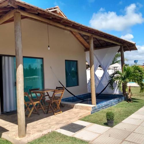 a patio of a house with a table and chairs at Bellíssimo Villaggio in Porto De Galinhas