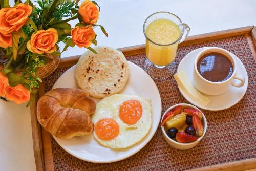 bandeja de desayuno con huevos, pan y una taza de café en Hotel Boutique los Remansos, en Palmira