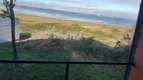 a view of a beach from a balcony at CABAÑAS MAR BRAVA in Ancud