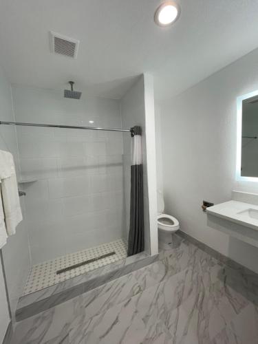 uma casa de banho com um chuveiro, um WC e um lavatório. em Casa Bell Motel, Los Angeles - LAX Airport em Inglewood